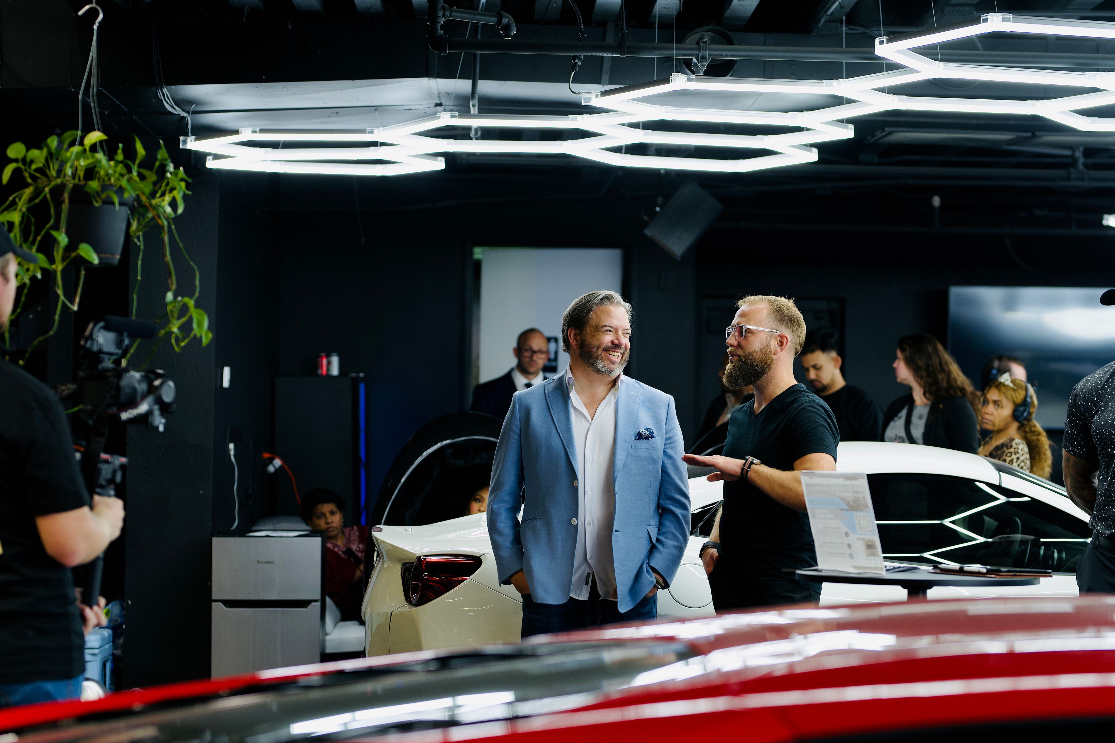 Tesla Emp entrepreneur standing beside a premium vehicle